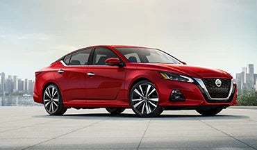 2023 Nissan Altima in red with city in background illustrating last year's 2022 model in Briggs Nissan in Manhattan KS